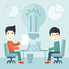 Image showing Two japanese businessmen sitting working together.