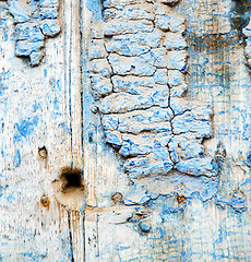 Image showing metal nail dirty stripped paint in the brown wood door and rusty