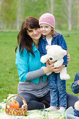 Image showing Mother hugs daughter at a picnic