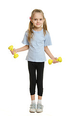 Image showing Six year old girl athlete engaged in exercise with dumbbells