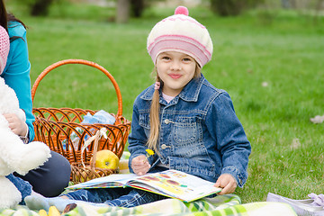 Image showing girl of five years sitting on a green lawn