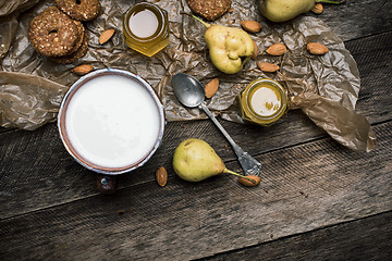 Image showing Almonds pears Cookies and milk on wooden table