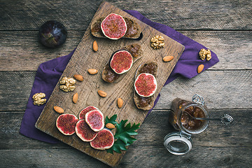 Image showing figs, nuts and bread with jam on choppingboard in rustic style