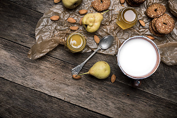 Image showing Nuts pears Cookies and milk on wooden table