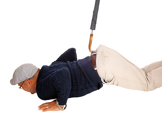 Image showing Man lying on floor pulled up with umbrella.