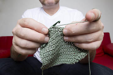 Image showing Closeup of a man knitting a scarf