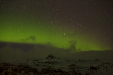 Image showing Northern lights with snowy mountains in the foreground
