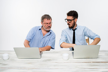 Image showing The two colleagues working together at office on white background