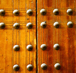 Image showing metal nail dirty stripped paint in the brown   red wood door and