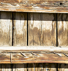 Image showing nail dirty stripped paint in the brown wood door and rusty yello