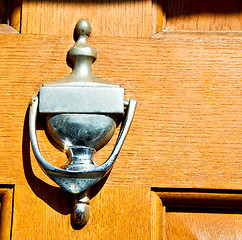 Image showing handle in london antique brown door  rusty  brass nail and light