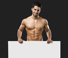 Image showing Sexy young man holding a cardboard