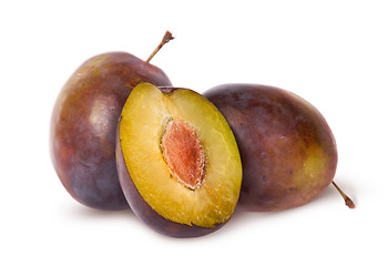 Image showing Half and two violet plums
