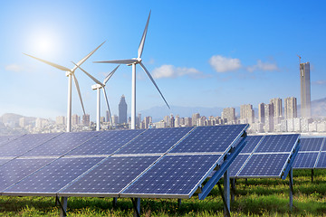 Image showing Solar panels and wind turbines with city