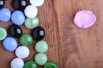 Image showing spa stones and flower petals on wooden table, closeup