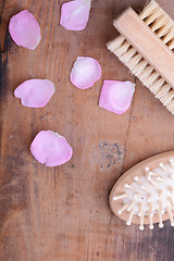 Image showing hair brush, rose flower petals, comb on wooden plate