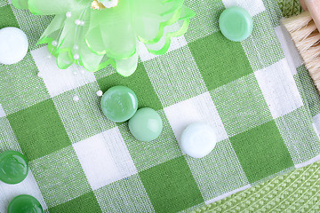 Image showing spa settings, green towel with white and green spa stone, hairbrush