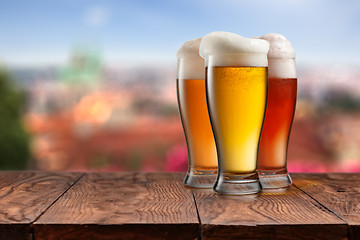 Image showing Glasses of different beer on wooden table against Prague