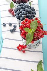Image showing Red currants and blueberries in small metal buckets