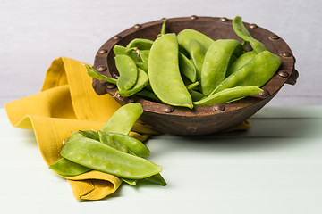 Image showing Snow peas on wooden bowl