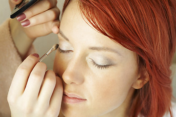 Image showing beautician is doing make-up to red-haired woman