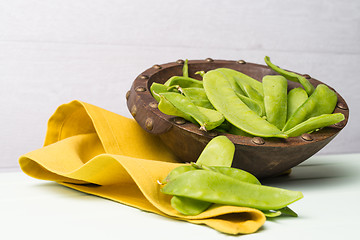Image showing Snow peas on wooden bowl