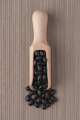 Image showing Wooden scoop with black beans