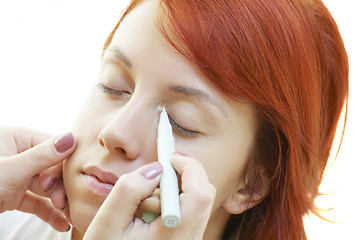 Image showing beautician is doing make-up to red-haired woman