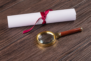 Image showing Wrapped paper sheets and magnifying glass