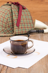 Image showing Coffee cup, paper sheets and detective hat