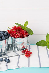 Image showing Red currants and blueberries in small metal buckets