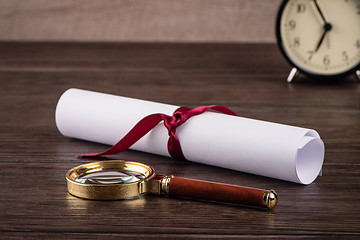 Image showing Wrapped paper sheets and magnifying glass