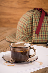 Image showing Coffee cup, paper sheets and detective hat