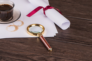 Image showing Wrapped paper sheets and magnifying glass