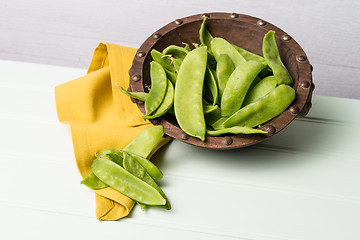 Image showing Snow peas on wooden bowl