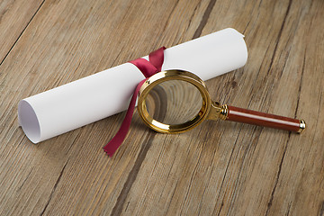 Image showing Wrapped paper sheets and magnifying glass