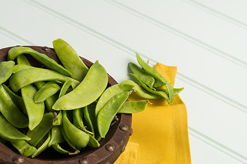 Image showing Snow peas on wooden bowl