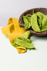 Image showing Snow peas on wooden bowl