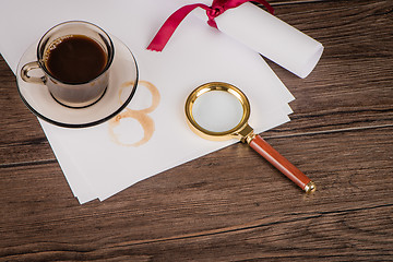 Image showing Coffee cup, paper sheets and detective hat