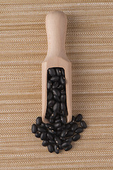 Image showing Wooden scoop with black beans