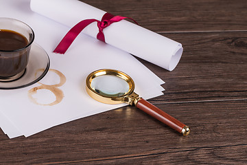 Image showing Coffee cup, paper sheets and detective magnifying glass