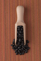 Image showing Wooden scoop with black beans