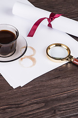 Image showing Coffee cup, paper sheets and detective magnifying glass