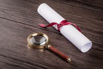 Image showing Wrapped paper sheets and magnifying glass