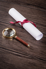 Image showing Wrapped paper sheets and magnifying glass