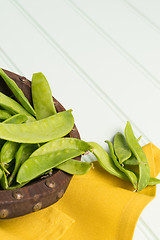 Image showing Snow peas on wooden bowl