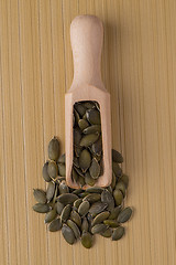 Image showing Wooden scoop with pumpkin seeds