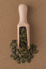 Image showing Wooden scoop with pumpkin seeds