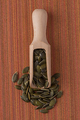 Image showing Wooden scoop with pumpkin seeds