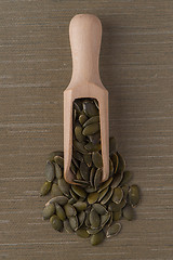 Image showing Wooden scoop with pumpkin seeds